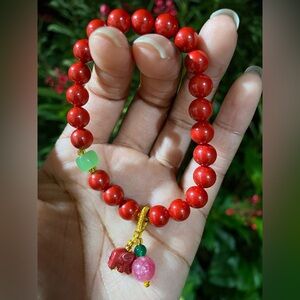 Red beaded bracelet with jade focal bead and elephant charm
